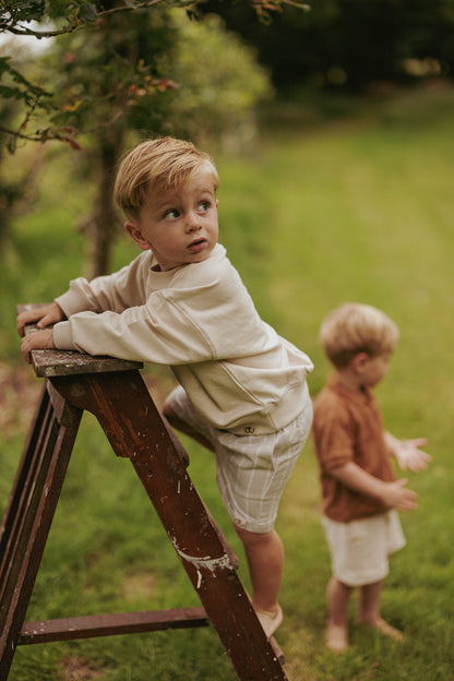 Jongen in kinderkleding van jongensmerk Mr. Loutre klimt op trap 