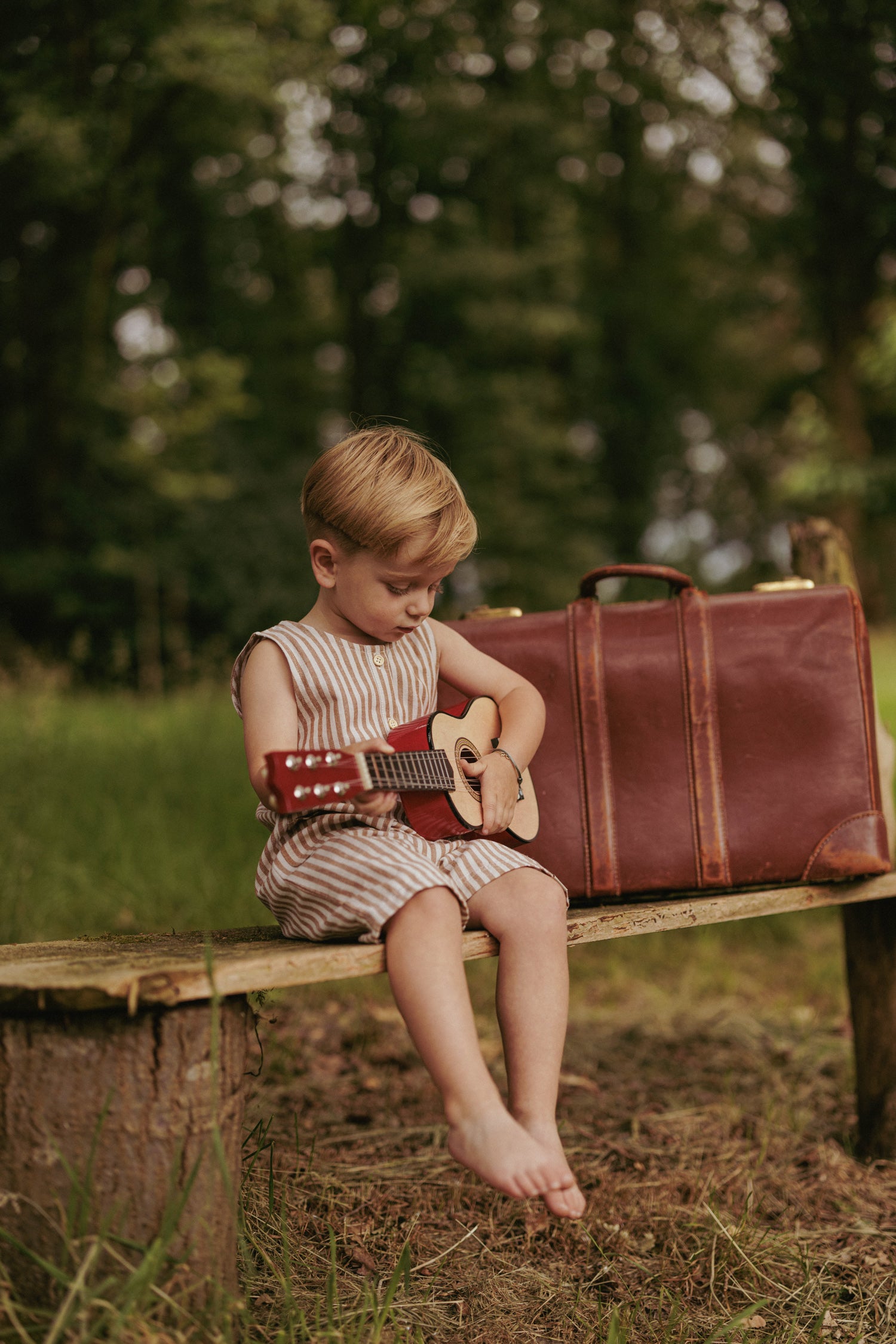 Kindje met gitaar in gestreepte Benjamin playsuit voor jongens